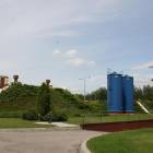 Zbiorniki retencyjne są ukryte pod maskującą zielenią. Niebieskie wieże - tzw. deszczownie